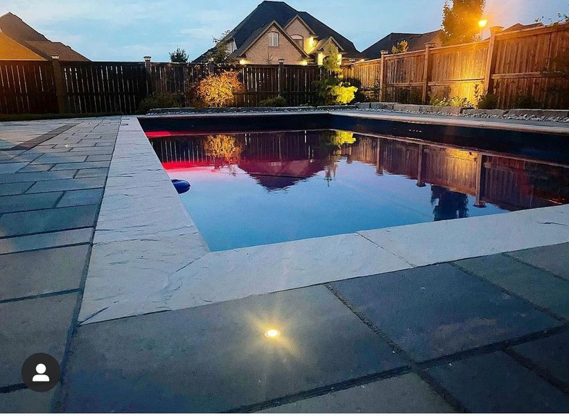 Fiberglass pool at dusk with bluestone coping and integrated lighting