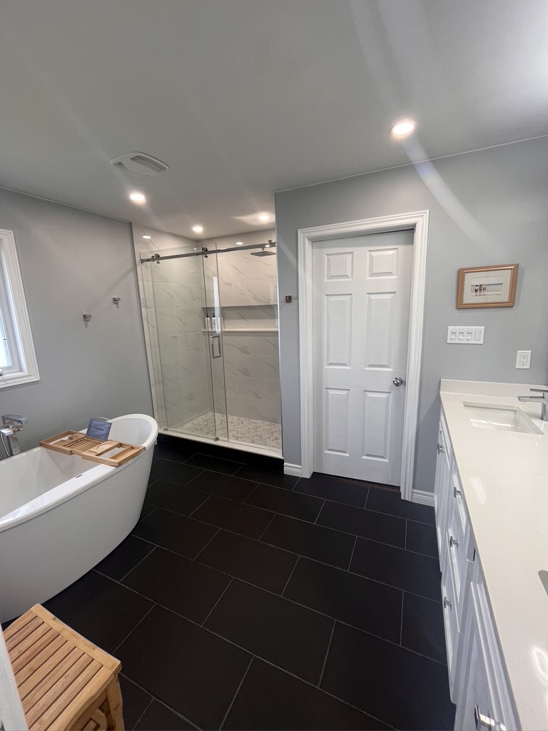 Renovated bathroom with freestanding tub and glass shower